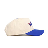 The No Rivals Boise Hometown Hat is a cream cotton baseball cap with a blue curved brim and embroidered front letters, pictured from the left side on a white background.