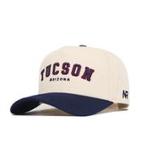The No Rivals Tucson Hometown Hat is a beige cotton baseball cap with a dark blue brim, featuring "TUCSON" in bold blue and red above "ARIZONA" and "NR" stitched on the side for a structured, classic look.