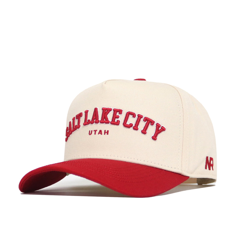 The No Rivals Salt Lake City Hometown Hat is a cream cotton cap with a red brim. “Salt Lake City Utah” and “AR” are embroidered in red for style and pride. Enjoy its comfortable, structured fit.