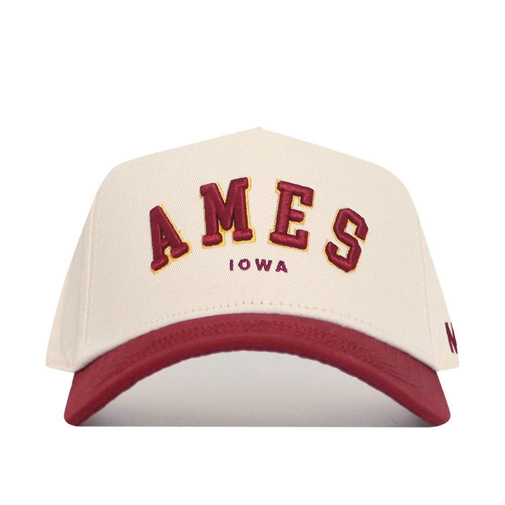 The No Rivals Ames Hometown Hat features a cream cotton structured fit, maroon bill, "AMES" in large maroon and gold letters, and "IOWA" in smaller maroon below.