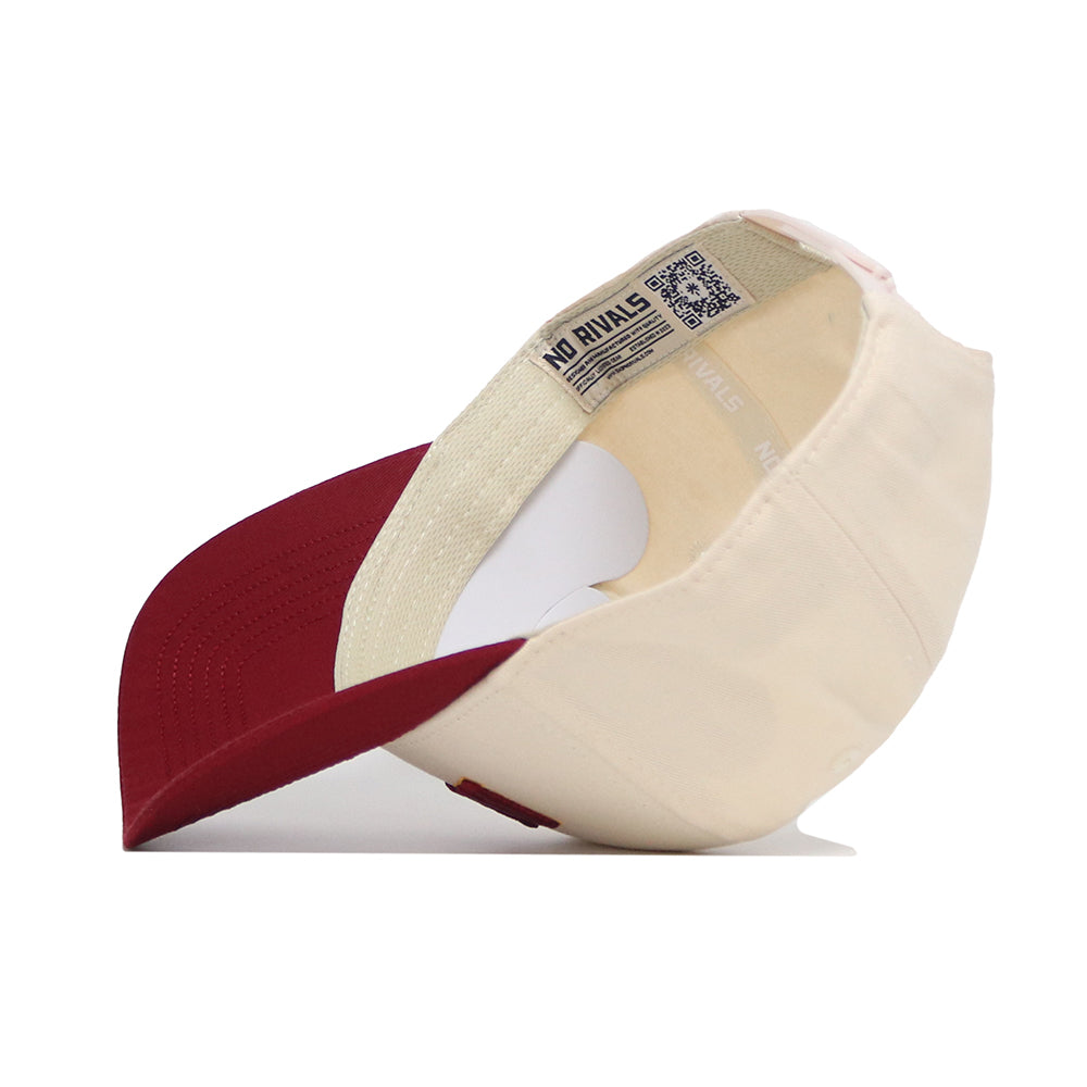 The Ames Hometown Hat by No Rivals is shown upside down, revealing the inside tag and a QR code on the inner band. This cream and burgundy snapback features a structured fit, flat brim, round crown, and high-quality cotton construction.