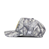 Side view of the Oregon Outland Hat by No Rivals, a snapback cap in high-quality cotton with a camouflage branch pattern, yellow embroidered front logo, and white NR initials on the side.