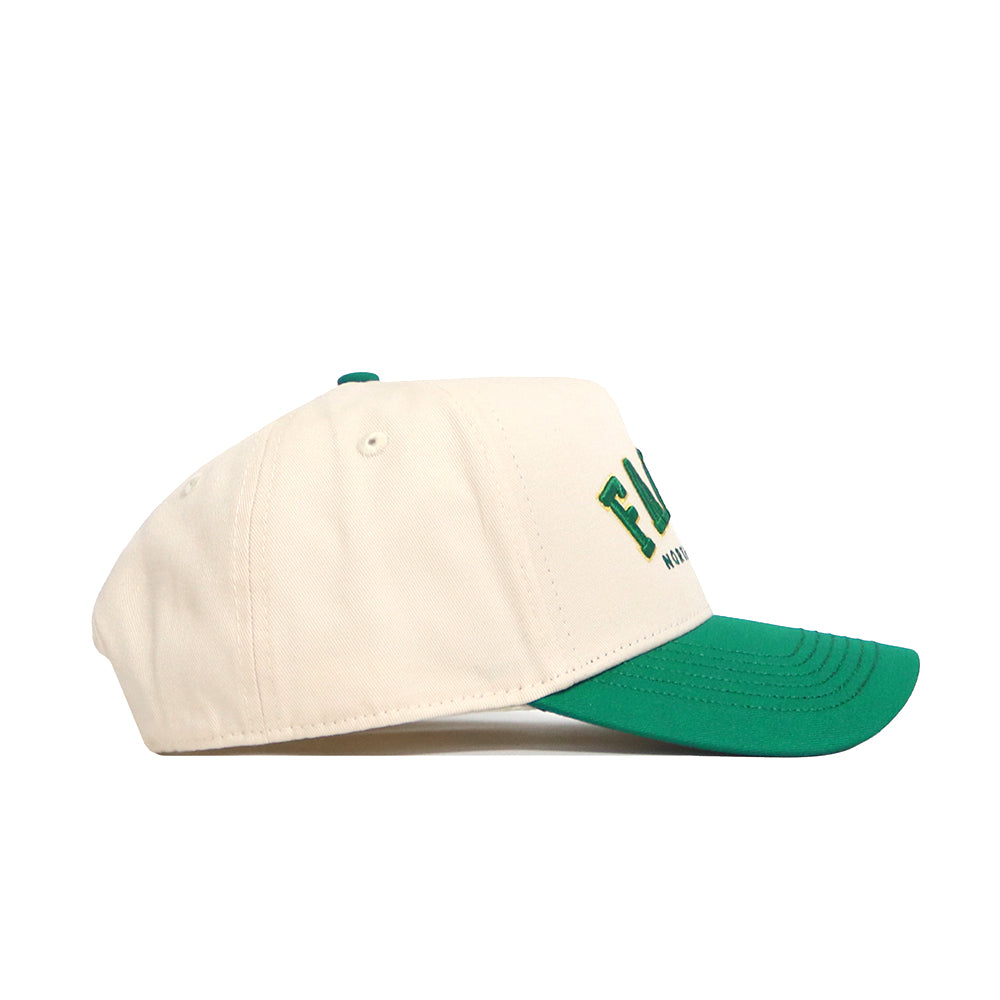 The Fargo Hometown Hat by No Rivals is a cream baseball cap with a green brim and top button, partial green and yellow front lettering, and a comfortable structured fit made from high-quality cotton.