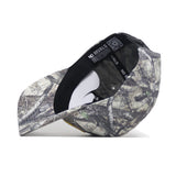 The Oregon Outland Hat by No Rivals is shown upside down, displaying its black NO RIVALS sweatband and a white tag. Made from high quality cotton, the cap features a forest camouflage pattern.