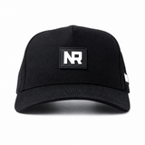 The NR Athletic Golf Hat - Coal by No Rivals is a black snapback with a structured fit, bold white NR patch on the front, small side patch, and made from a soft polyester-cotton blend. Background is plain white.