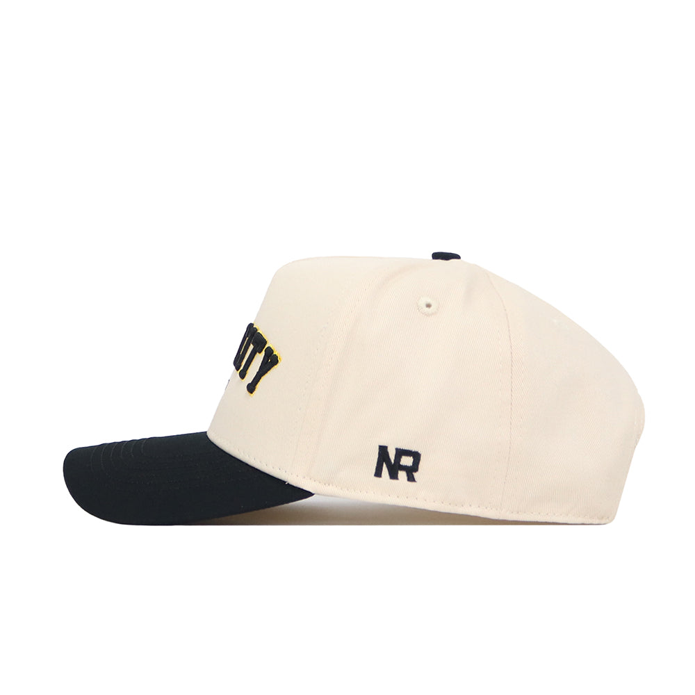 The Iowa City Hometown Hat from No Rivals is a cream snapback with a black brim, yellow and black front design, and black NR embroidery on the side. Crafted from high quality cotton for comfort and durability.