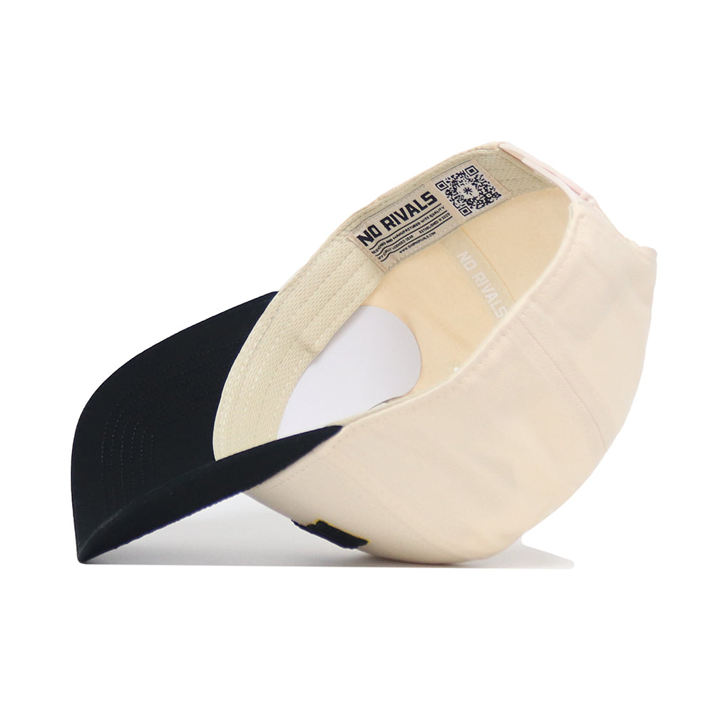 The Iowa City Hometown Hat by No Rivals is a beige and black baseball cap with a curved black brim, structured beige crown, and an inside label featuring "No Rivals" and a QR code.