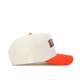 The Oklahoma State Retro Block Hat by No Rivals is a beige baseball cap with an orange brim and top button, shown from the side. The structured front panel has partially visible red and black embroidered text for a sharp look.