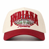 The Indiana Hoosiers Stadium Hat by No Rivals features a cream and red design with an embroidered “Indiana” and “Hoosiers” logo above and below a detailed football stadium graphic, and is finished with a classic snapback closure for the perfect gameday fit.