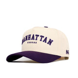 The Manhattan Hometown Hat by No Rivals is a structured beige cotton cap with a purple curved brim, "MANHATTAN KANSAS" in purple and black embroidery, "AR" stitched on the side, and an adjustable snap back for comfort.