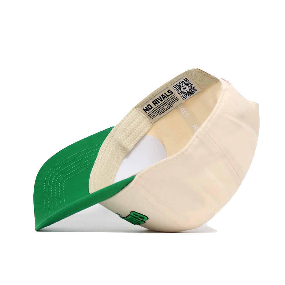 The Grand Forks Hometown Hat by No Rivals is a cream cotton baseball cap with a green visor, shown flipped to reveal the inside label, stitching, and NO RIVALS text on the structured inner band.