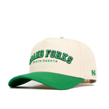 The Grand Forks Hometown Hat by No Rivals is a cream snapback with a green cotton brim, featuring "Grand Forks North Dakota" embroidered in green on the front and small green NR initials on the side.