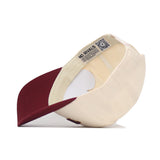 The Tempe Hometown Hat by No Rivals is a cream-colored, structured fit cap with a maroon brim, shown upside down to reveal inside tags, including NO RIVALS text and a QR code. Made from high-quality cotton for comfort and durability.
