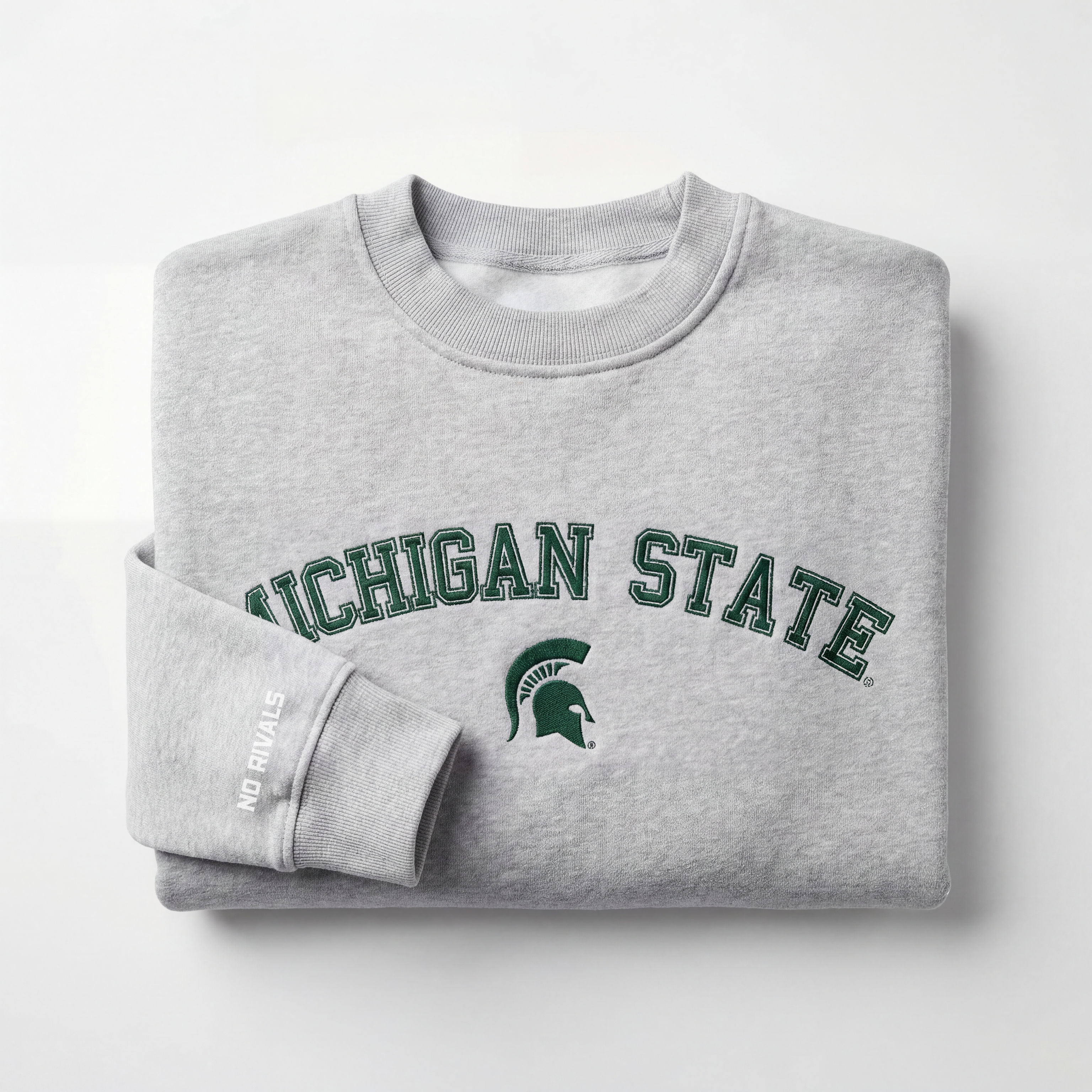 The Michigan State Mock Neck by No Rivals is a folded gray heavyweight cotton sweatshirt featuring "MICHIGAN STATE" and a green Spartan helmet on the front, plus "NO RIVALS" in white near the cuff, set on a plain white background.