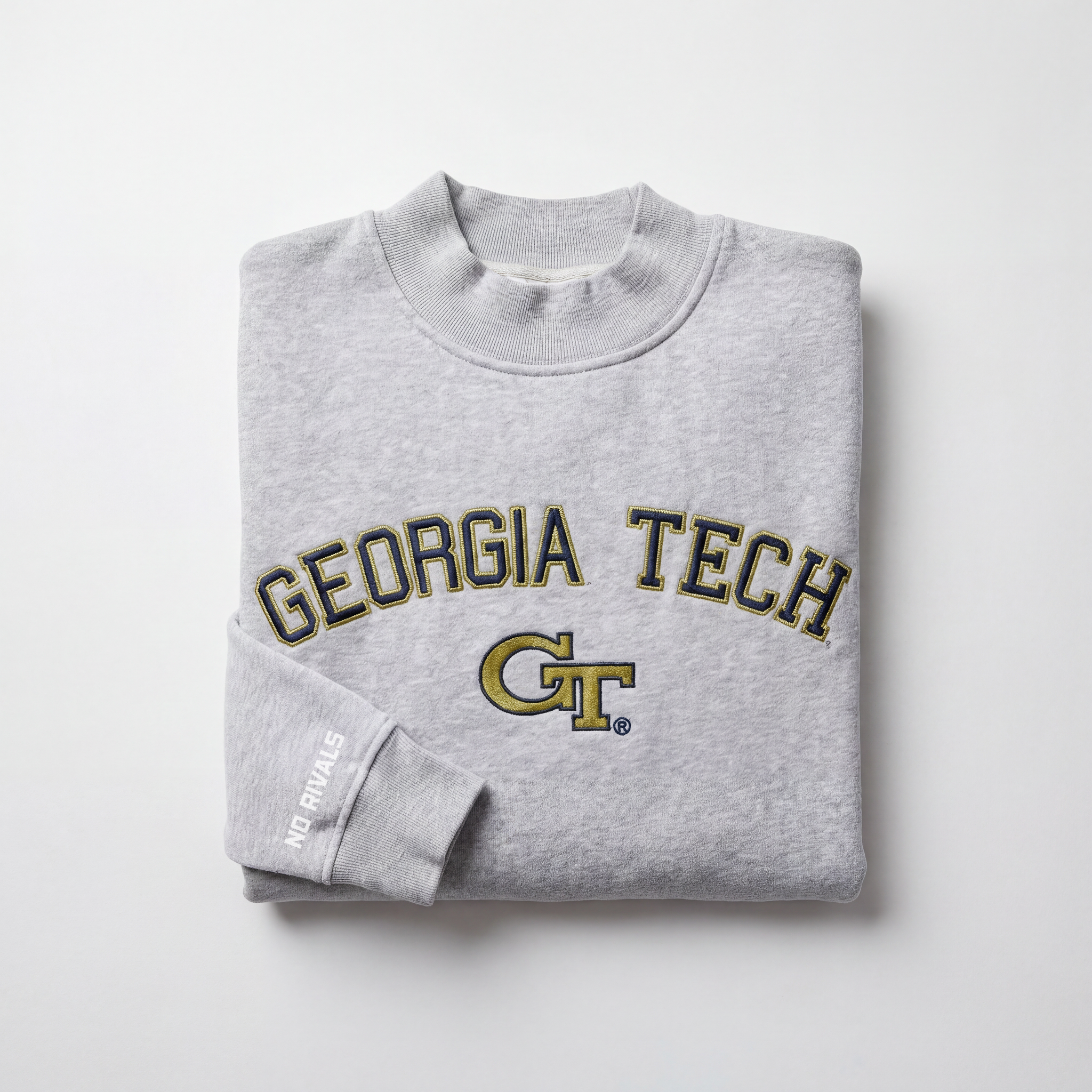 The Georgia Tech Mock Neck by No Rivals is a heavyweight gray, oversized sweatshirt with GEORGIA TECH and the GT logo in yellow and black on the front, plus "NO RIVALS" text on the sleeve, shown folded on a plain white background.