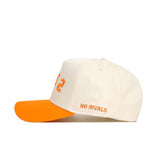 The Right Side Up VOLS Hat by No Rivals is a cream snapback with an orange brim, high-quality cotton, “NO RIVALS” in orange on the side, and partially visible orange text on the structured front.