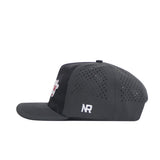 A side view of the Nebraska Cornhuskers Military Appreciation Hat by No Rivals, a black snapback with a structured fit, small ventilation holes, flat brim, NR embroidered in white on the side, and a partially visible front logo.
