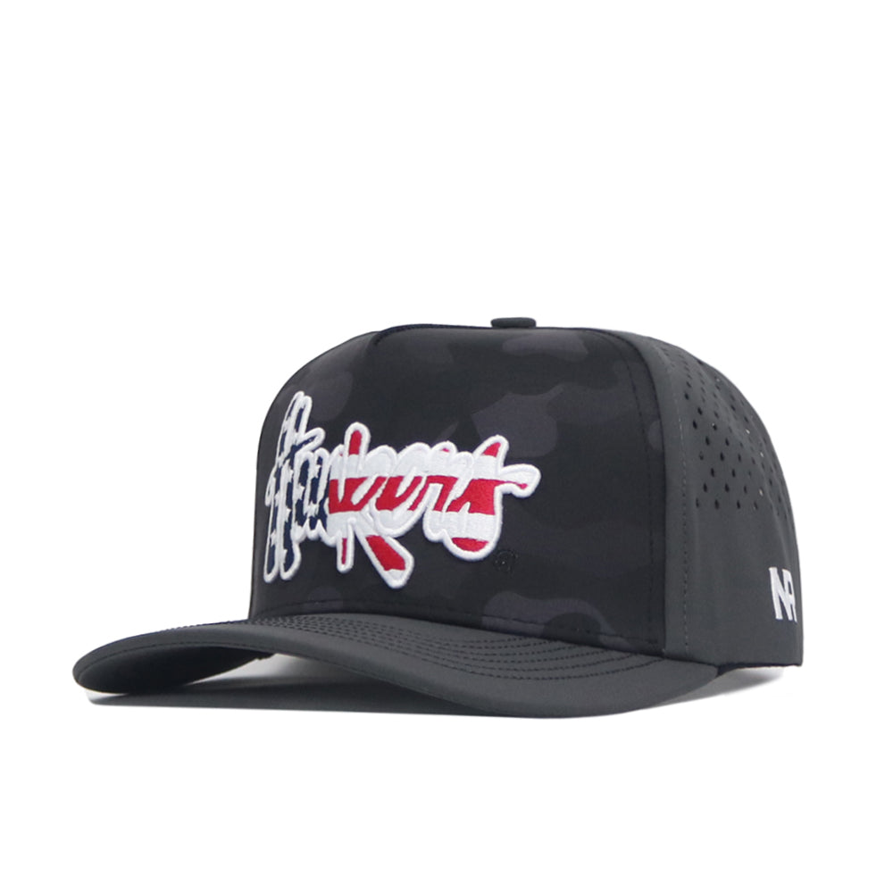 The No Rivals Nebraska Cornhuskers Military Appreciation Hat is a structured black camo baseball cap with bold white and red "Hukunt" embroidery up front, small "NP" initials on the side, snapback adjustment, and ventilation holes for comfort.