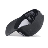 The Georgia Bulldogs Military Appreciation Hat by No Rivals is shown upside down, revealing the inside label with NO RIVALS, a QR code, and embroidered logo. This black cap has ventilation holes and a snapback closure for an adjustable fit.