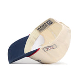 The USA Classic Americana Hat by No Rivals is a cream and navy snapback, shown from below to display the “NO RIVALS” label, QR code on the inner band, and “2504” stitched tag on its structured cotton crown.