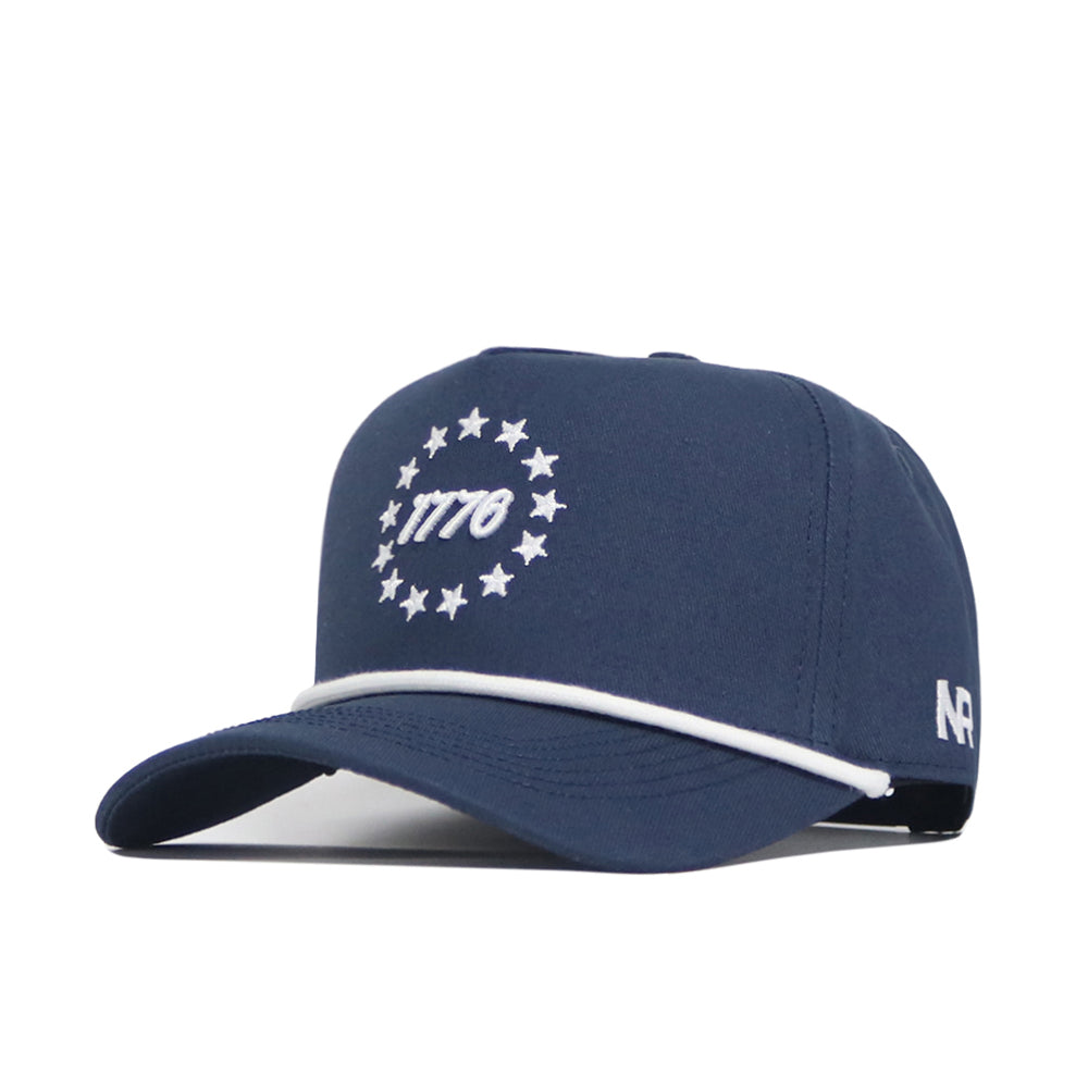 The No Rivals USA 1776 Americana Hat is a navy cotton baseball cap with "1776" and stars embroidered in white, a structured fit, white trim on the brim, and a small white N4 on the side.