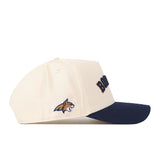 Introducing the No Rivals Right Side Up Bobcats Hat - Montana State - Classic: This cream baseball cap features a navy blue brim, an embroidered bobcat logo on the side, and “BOBCATS” in bold navy text across the front. Designed with a classic Snap Back closure, this hat is the perfect way to complete your Gameday outfit.
