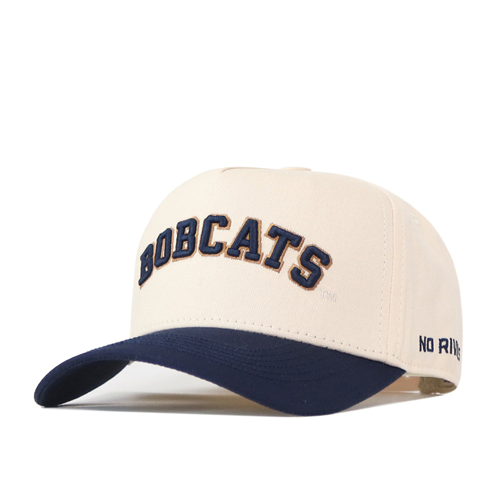 Show your Montana State spirit with the Right Side Up Bobcats Hat - Classic from No Rivals. This cream-colored baseball cap features a large embroidered BOBCATS logo in navy across the front and “NO RIVALS” stitched in small letters on the left side of the navy blue brim. With its classic snapback closure, this hat is a perfect addition to your gameday fit.