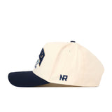 A cream-colored Georgia Tech Yellow Jackets Stadium Hat by No Rivals, featuring a navy blue brim and side profile view. The embroidered “NR” logo in navy appears near the back, while an adjustable snap back ensures the perfect fit for gameday.