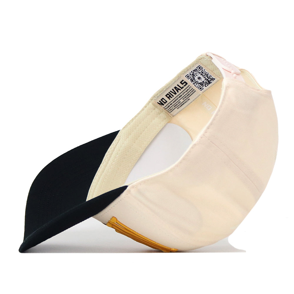 A Missouri Tigers Stride Hat by No Rivals, in beige and black, is flipped upside down to display the inside tags, QR code, and officially licensed details. The cap features embroidered logos and a yellow accent near the brim.