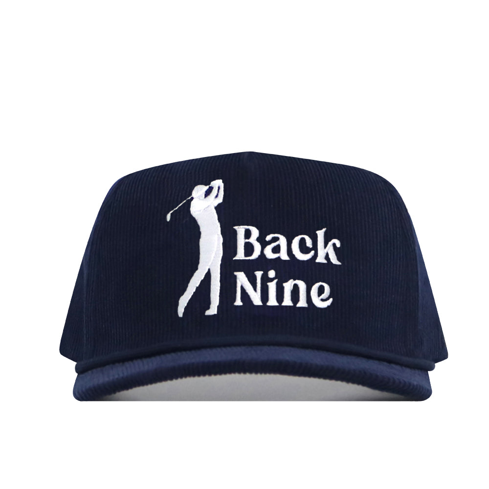 The Back Nine Cord Hat - Navy by No Rivals features cotton corduroy fabric, an embroidered white golfer silhouette with "Back Nine" on the front, and an adjustable snap back closure.