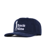 The No Rivals Back Nine Cord Hat - Navy is a cotton corduroy snapback cap with white embroidered "Back Nine" text and a golfer swinging a club on the front.