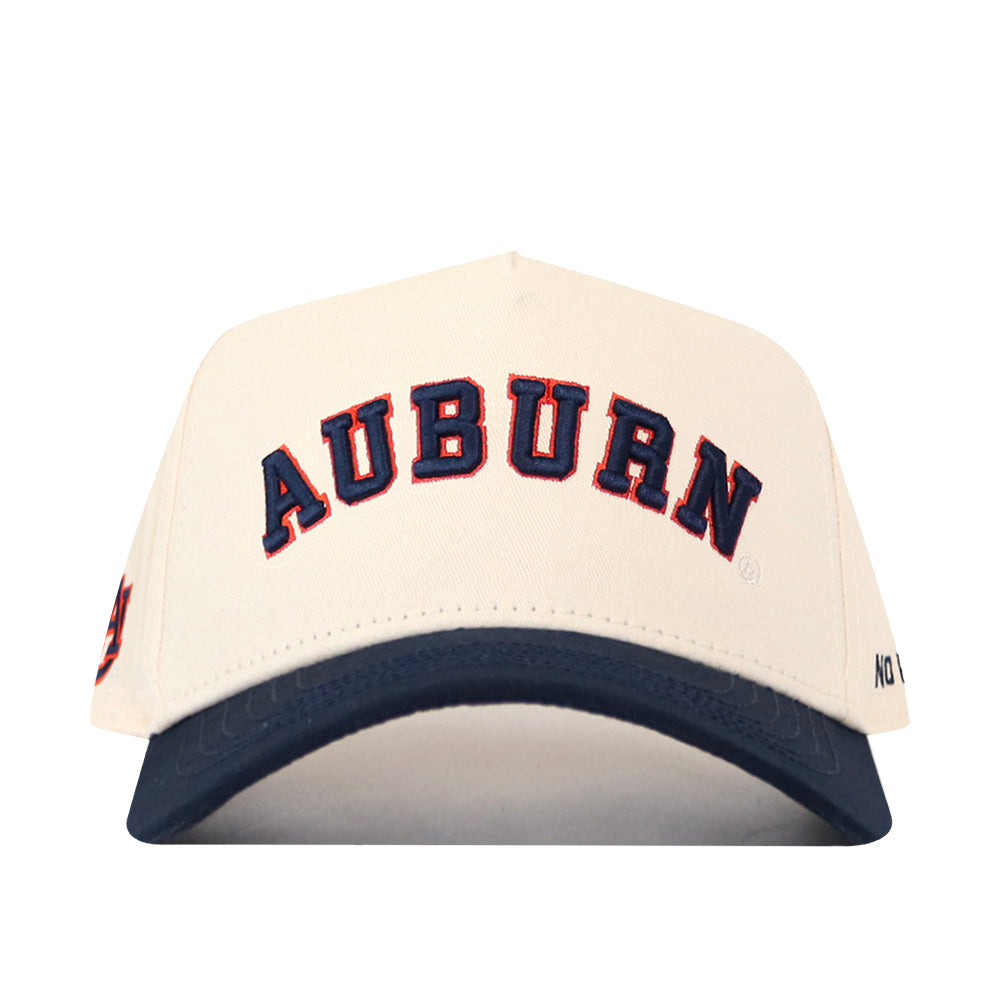 Introducing the Right Side Up Auburn Hat - Classic Colors by No Rivals: This cream-colored snapback baseball cap features “AUBURN” embroidered in bold navy blue and orange letters on the front. Finished with a navy blue bill, it delivers a classic gameday look with its standout embroidered logo.