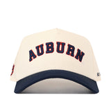 Introducing the Right Side Up Auburn Hat - Classic Colors by No Rivals: This cream-colored snapback baseball cap features “AUBURN” embroidered in bold navy blue and orange letters on the front. Finished with a navy blue bill, it delivers a classic gameday look with its standout embroidered logo.