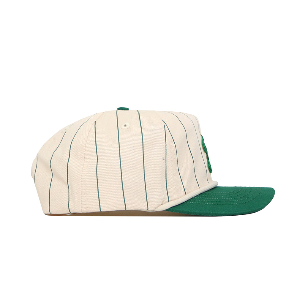The USF Pinstripe Hat by No Rivals is a cream-colored baseball cap with thin dark vertical stripes, a green flat brim, and soft cotton fabric, shown in a side view.