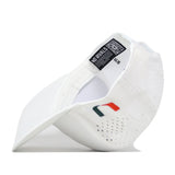 Introducing the Miami Hurricanes Football Mascot Hat - White by No Rivals: This white baseball cap is crafted from performance fabric for breathability and comfort, featuring a curved brim, side perforations, a small embroidered red, green, and orange Miami Hurricanes logo on the side, and a black interior tag. The cap is displayed on its side to highlight the detailed interior craftsmanship.