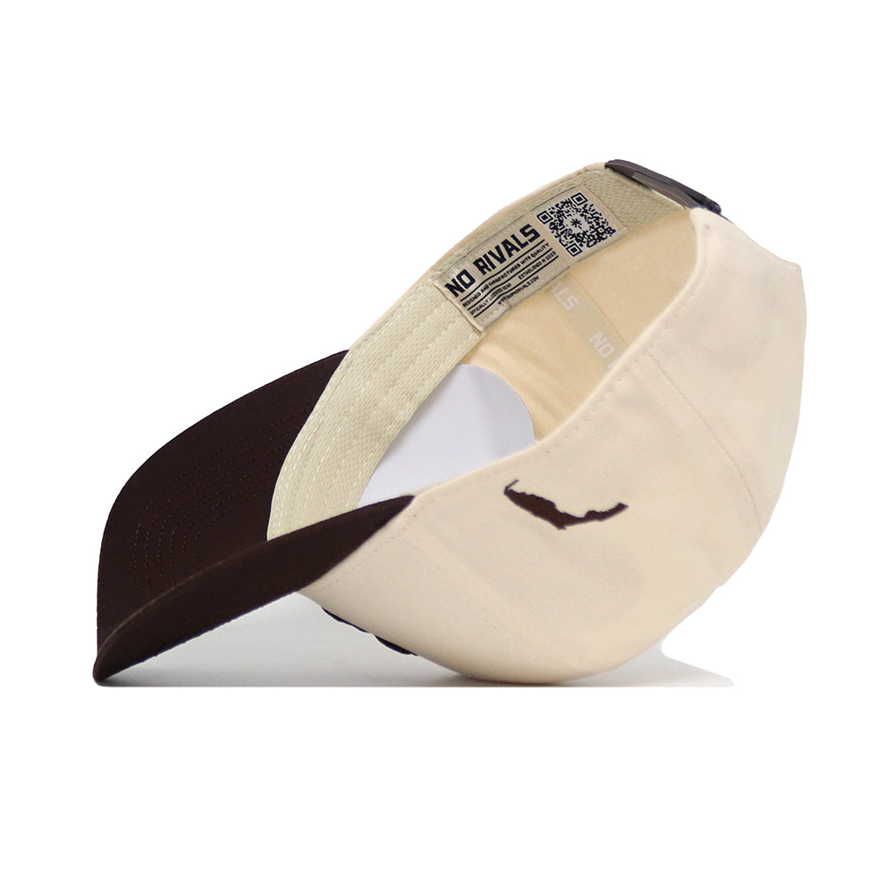 The USF Espresso Hat by No Rivals is displayed upside down, revealing the inside NO RIVALS label. Made from high-quality cotton, it features a brown and beige design, curved brim, outer mustache logo, and adjustable strap.