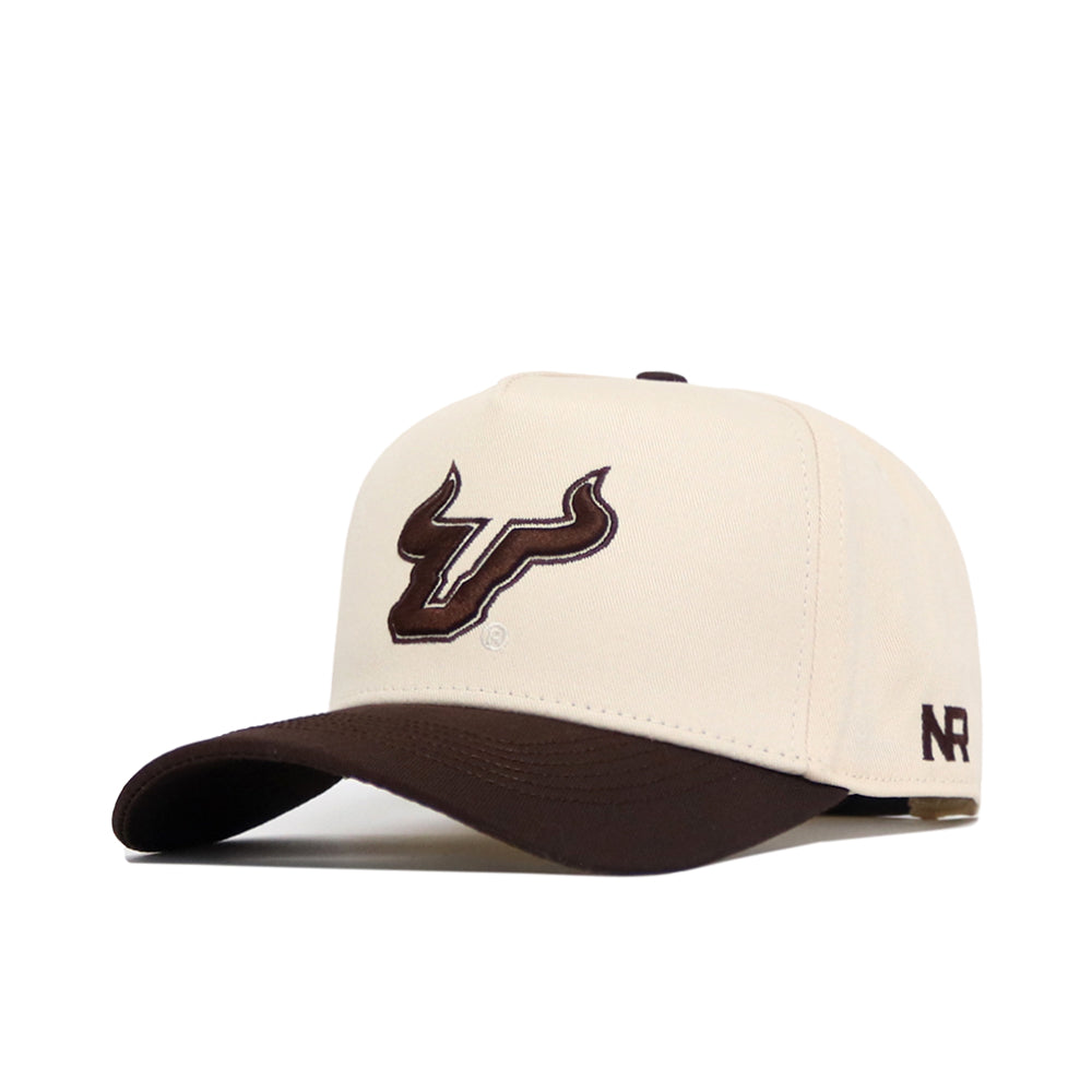 The No Rivals USF Espresso Hat is a beige cotton baseball cap with a dark brown curved brim, featuring a stylized bull head logo on the front and "NR" embroidered on the side.