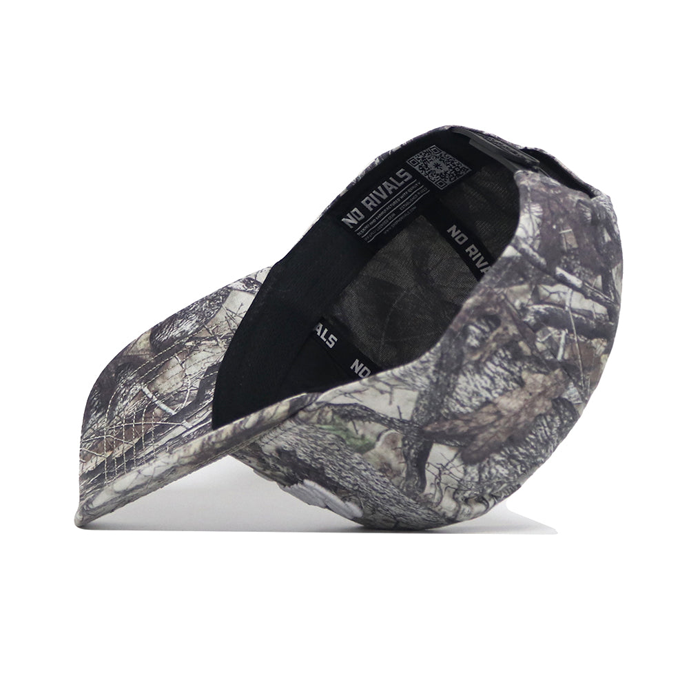 The Vandy Boys Outland Hat by No Rivals is a camouflage snapback, shown tilted to display its structured fit, with No Rivals branding on the sweatband and a barcode tag inside.