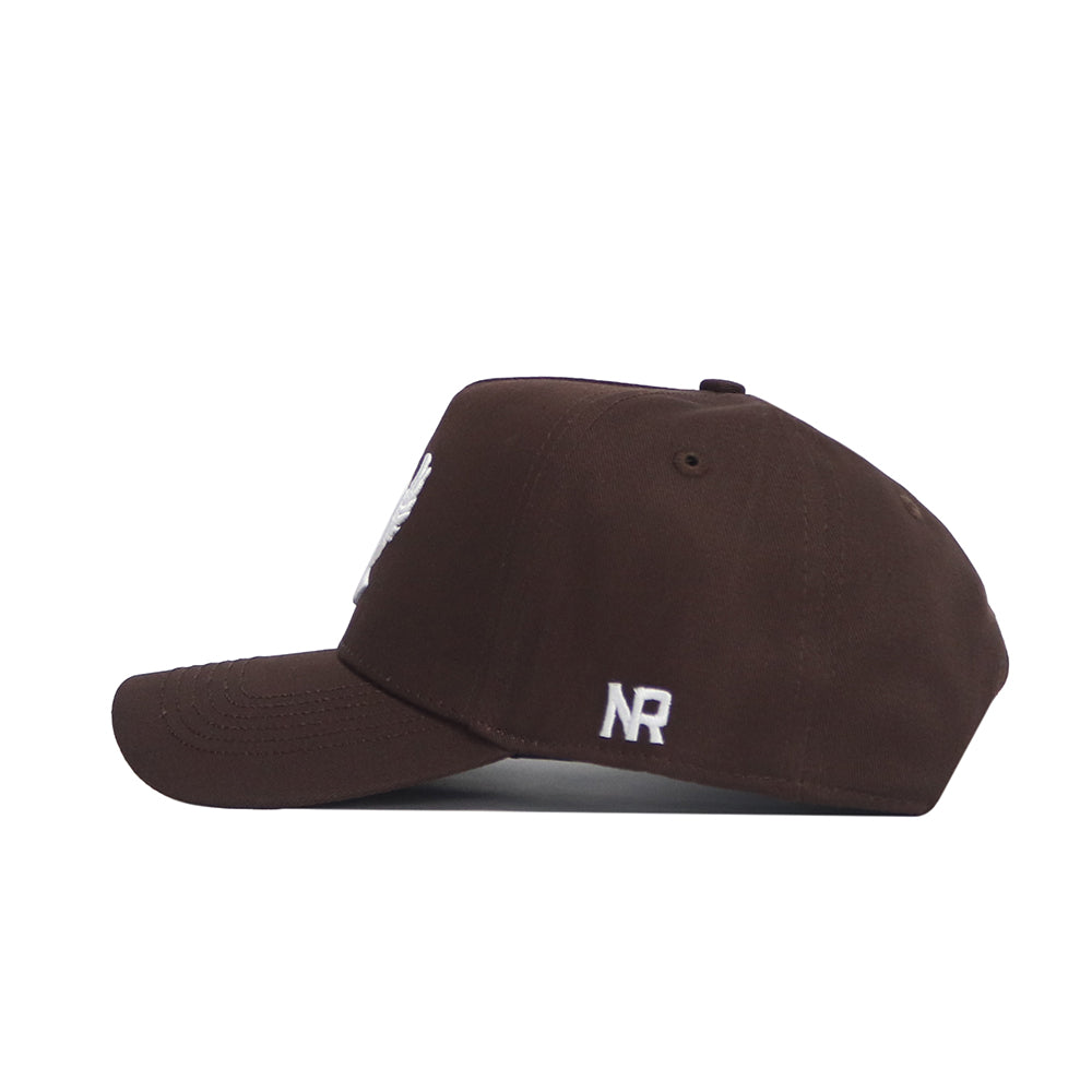 The EWU Americano Hat by No Rivals is a dark brown snapback shown from the side, featuring white embroidered NR lettering above the adjustable strap. Made from high-quality cotton for a comfortable, structured fit.