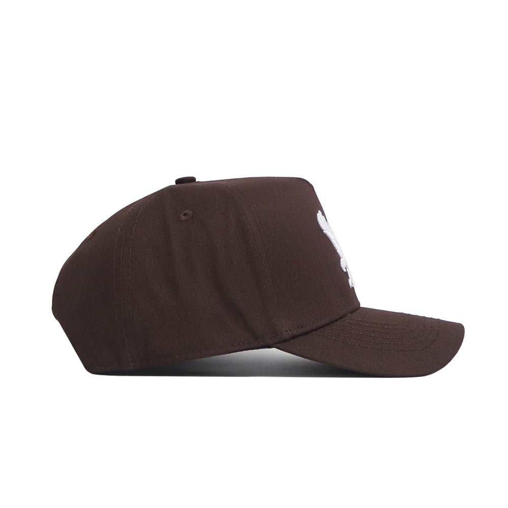 The No Rivals EWU Americano Hat is a brown snapback with a curved brim, visible stitching on quality cotton, and a partial white logo on the structured front panel, shown from the side.