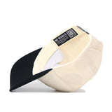 The Classic Colorado Buffs Hat is shown upside down, displaying its cream color with a black curved brim. Inside the structured cap, a label reads NO RIVALS beside a QR code and a white adjustable strap.