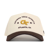 The Georgia Tech Yellow Jackets Outlaw Hat - Classic by No Rivals showcases cream and brown colors with “GEORGIA TECH JACKETS,” “1885,” “GT,” and “ATLANTA, GA” embroidered on the front, featuring a bold logo and an adjustable snap back for the perfect gameday fit.