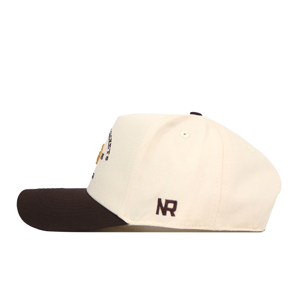 A cream-colored Georgia Tech Yellow Jackets Outlaw Hat - Classic by No Rivals, featuring a dark brown brim and the initials “NR” embroidered in dark brown near the back, is shown from the side. A classic snapback adjustment ensures a perfect fit for gameday.