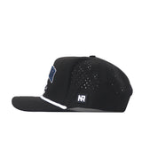 A side view of the Nevada Wolf Pack Golf Hat in black by No Rivals, showcasing small ventilation holes, a flat brim, and a white embroidered Wolf Pack logo on the front. The hat also features a rectangular NR logo patch on the side and is designed for the perfect Gameday Fit, with an adjustable snapback closure for personalized comfort.