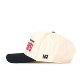 The Wisconsin Alma Mater Hat by No Rivals features a cream-colored snapback design with a black brim, red and black embroidered logos on the front, and “NR” stitched in black on the side.