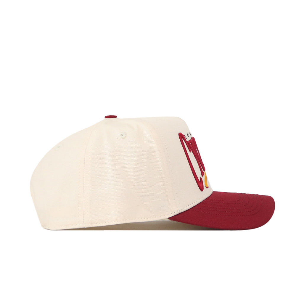 The Iowa State Cyclones Stride Hat by No Rivals is a cream-colored snapback featuring a flat maroon brim, shown in profile. Red and yellow embroidered logos are partially visible on the front panel, making it a perfect addition to your gameday fit.