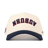Check out the Auburn Tigers | Upside Down Auburn Hat - Classic Colors by No Rivals: This unique snapback cap features a white crown with a navy blue brim. The word “AUBURN” is embroidered upside down on the front in blue, outlined in orange, making it a standout piece for fans.