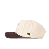 A side view of the Bowling Green State Falcons Espresso Hat by No Rivals, showcasing its cream-colored crown with a dark brown brim. The hat displays an officially licensed embroidered “NR” logo in brown near the back and is finished with a convenient snap back closure.