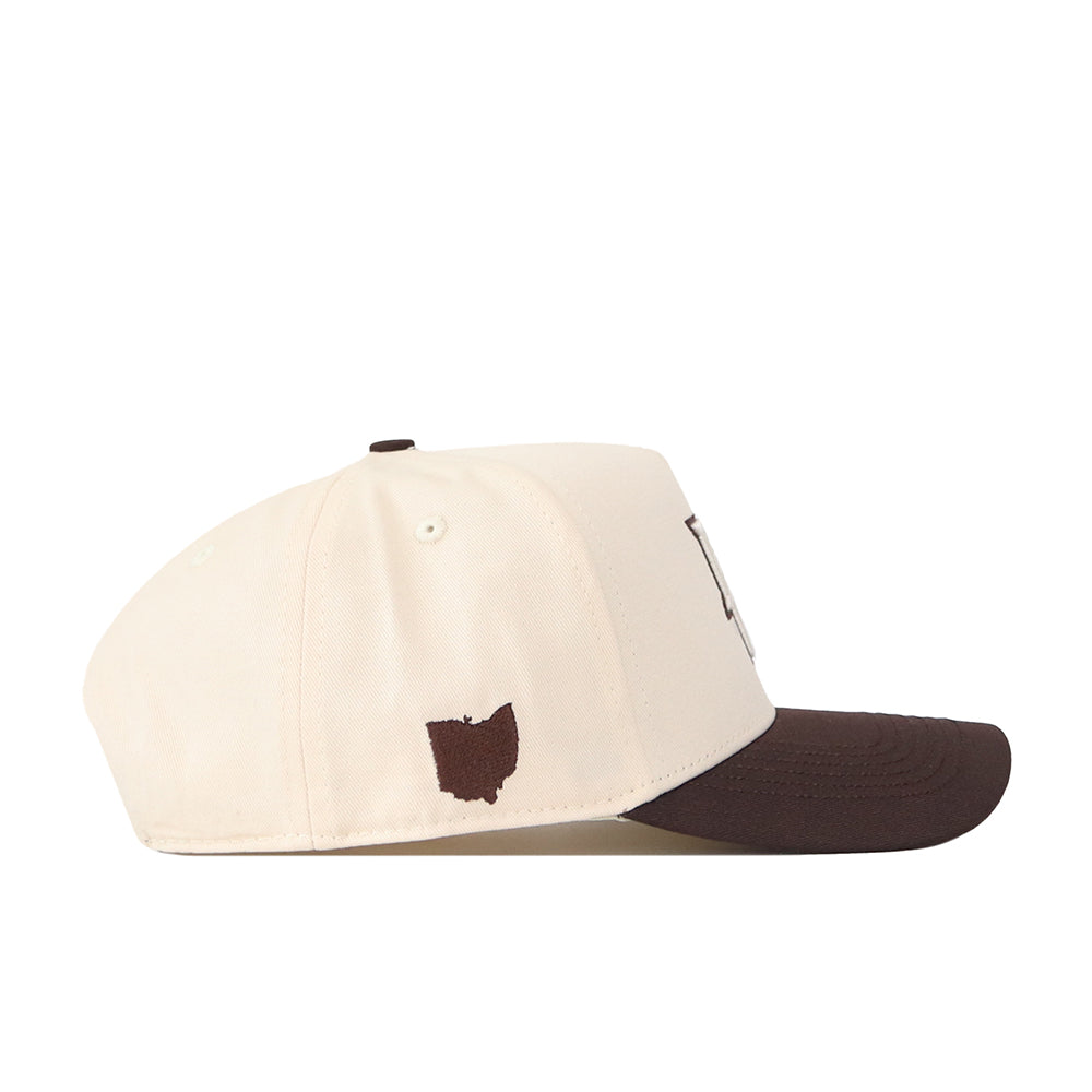 A side view of the No Rivals Bowling Green State Falcons Espresso Hat, a cream-colored baseball cap with a brown brim. This officially licensed snapback features a small brown outline of the state of Ohio embroidered near the back.
