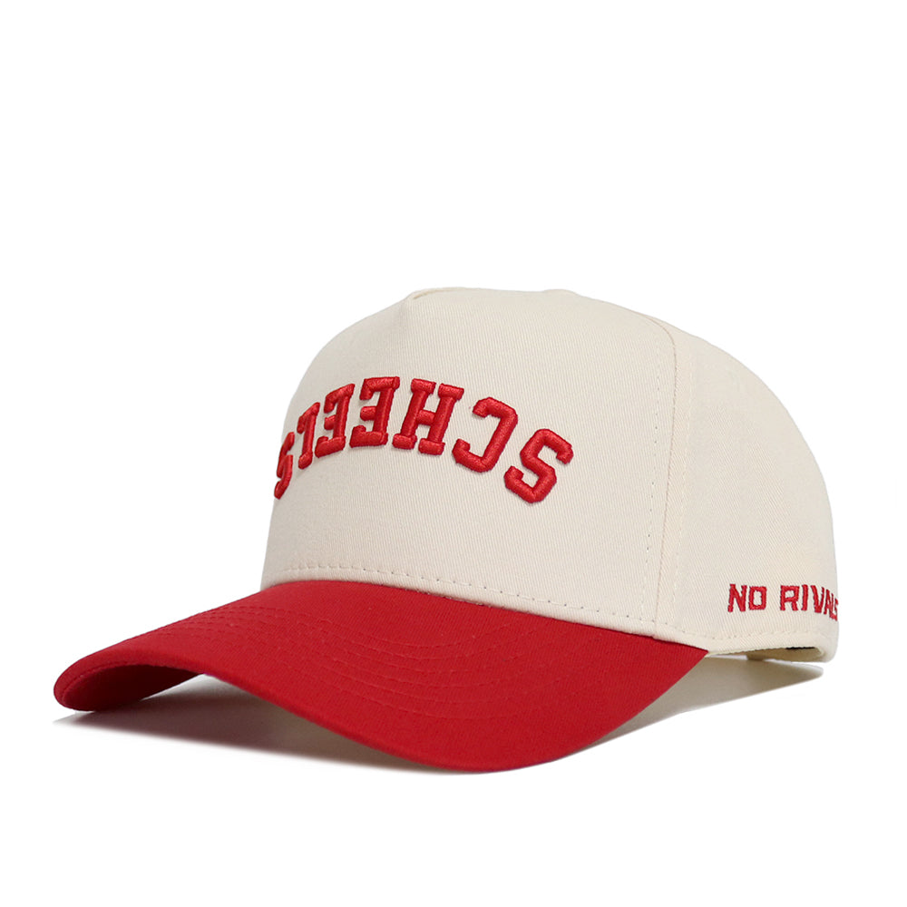 The Upside Down Scheels Hat is a beige and red snapback baseball cap made of high-quality cotton, with "SHEETS" embroidered upside down in red on the front and "NO RIVALS" stitched in red on the side.